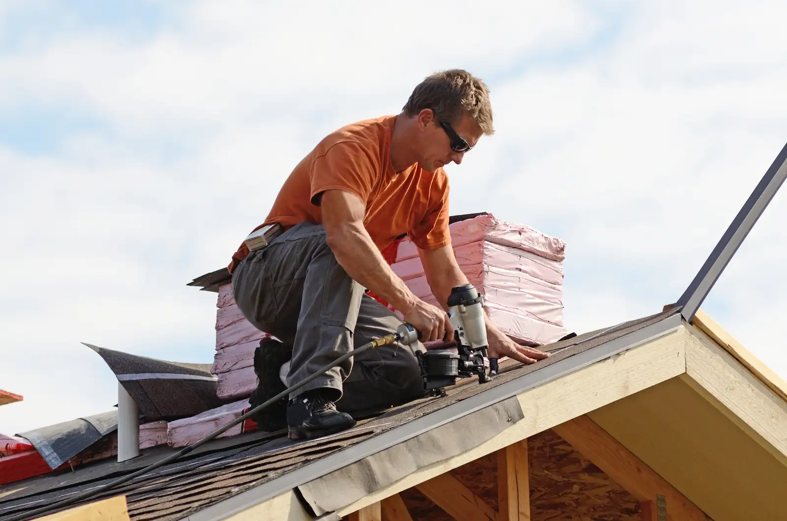 Roofer repairing damaged roof shingles